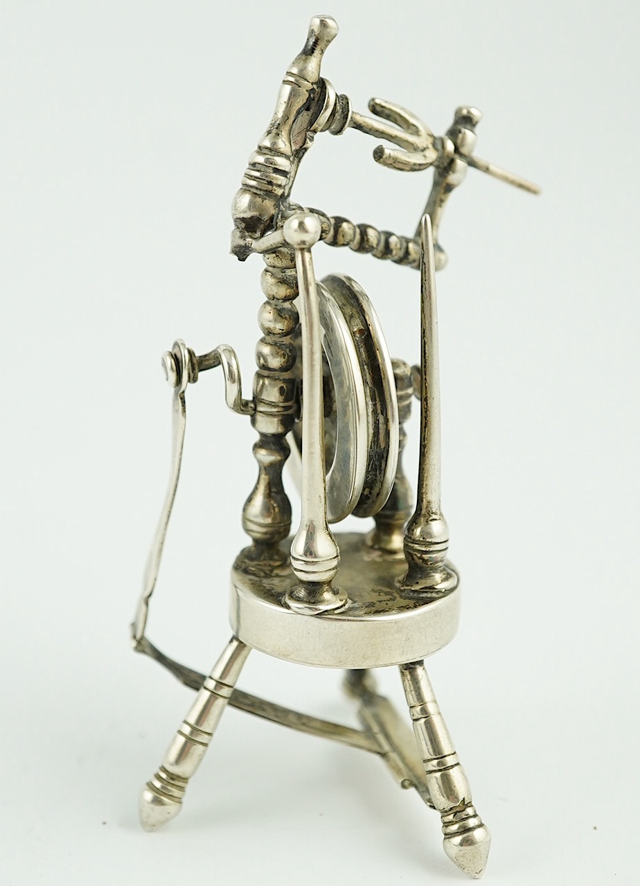 An Edwardian silver miniature articulated model spinning wheel, by Deakin and Francis Ltd, Birmingham 1905, 8.5cm and a cased set of coffee spoons, Sheffield 1936, with ‘bean’ terminals. Condition - fair